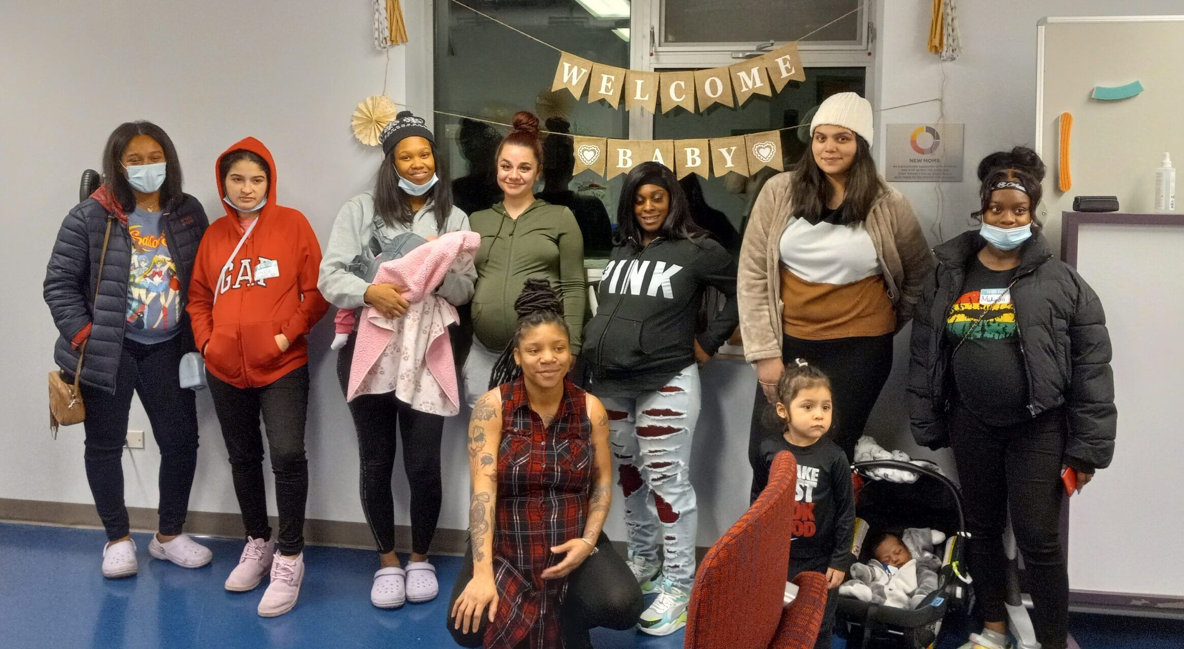 A group of young moms pose for a photo during their New Moms baby shower