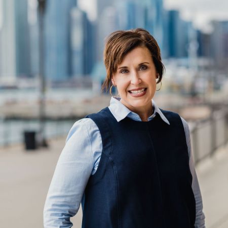 Laura Zumdahl, President & CEO of New Moms, smiling with skyline of Chicago in background.