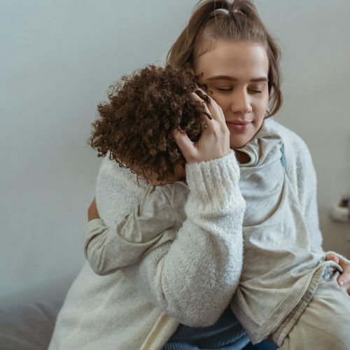 Mom hugging young child.